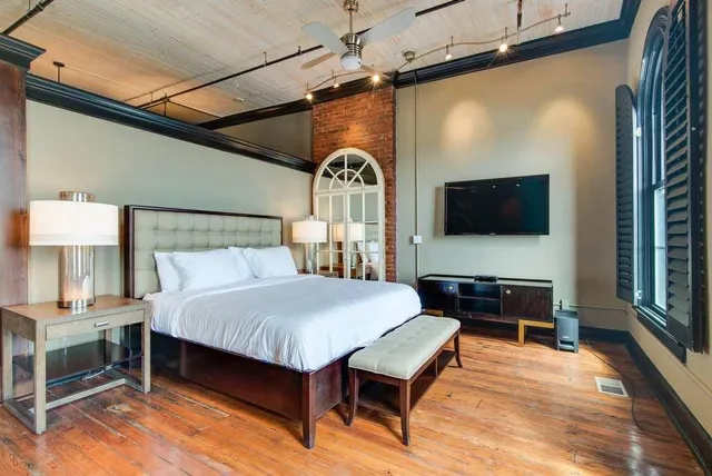 a bedroom with a bed and a flat screen tv