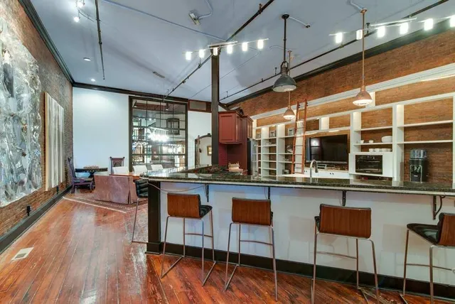 a kitchen with lots of counter and chairs