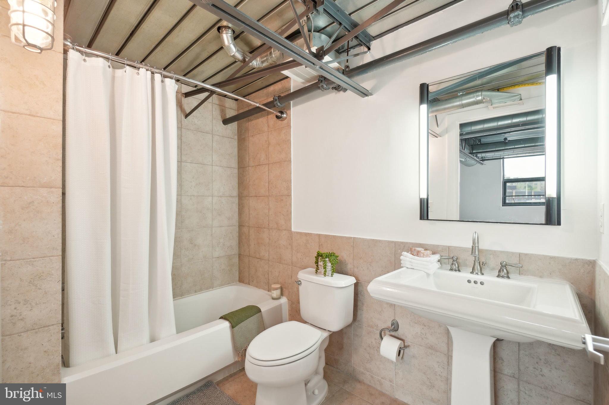 2301 Champlain Street Northwest, Unit 412 Washington, DC 20009 - Photo 14 of 20 a bathroom with a sink a toilet and shower