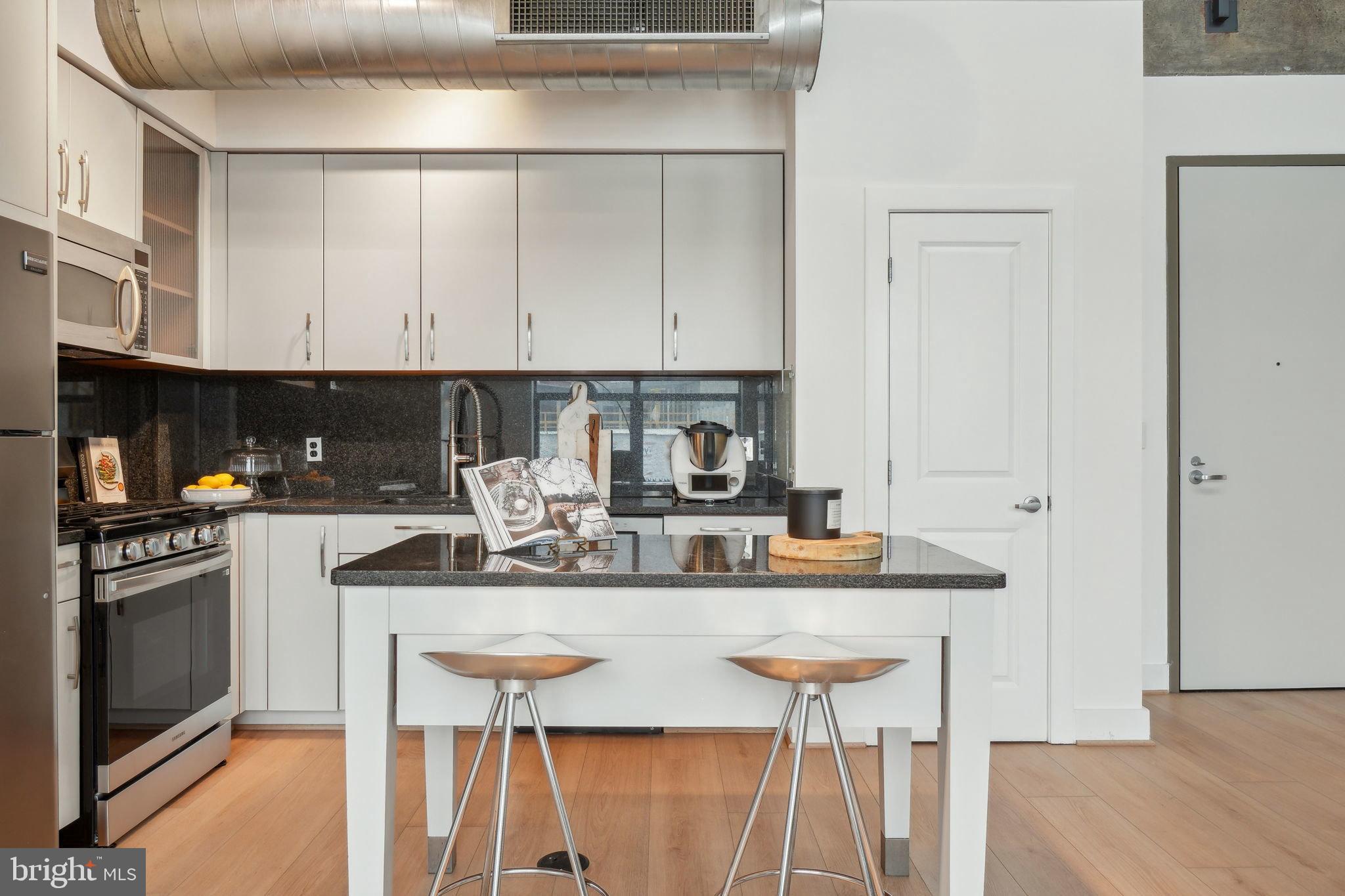 2301 Champlain Street Northwest, Unit 412 Washington, DC 20009 - Photo 3 of 20 a kitchen with stainless steel appliances granite countertop a sink stove and refrigerator