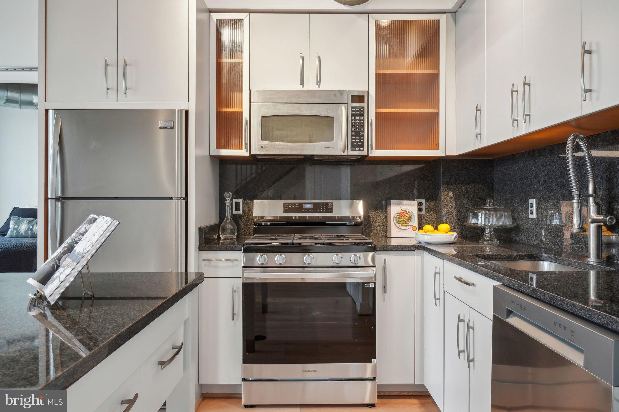 2301 Champlain Street Northwest, Unit 412 Washington, DC 20009 - Photo 4 of 20 a kitchen with granite countertop a sink stainless steel appliances and cabinets
