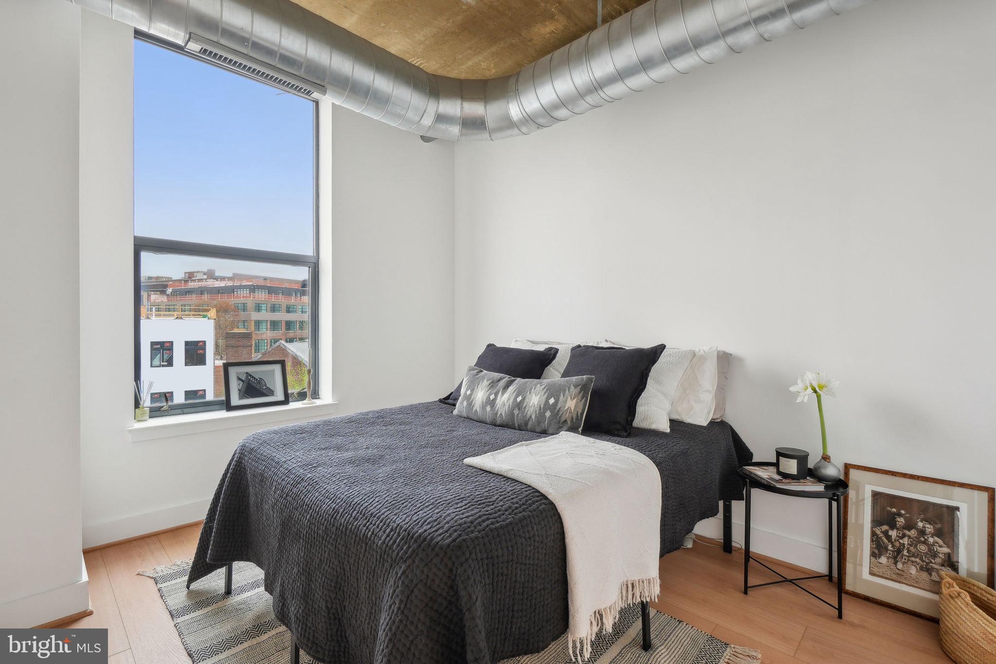 2301 Champlain Street Northwest, Unit 412 Washington, DC 20009 - Photo 7 of 20 a large bed sitting in a bedroom next to a window
