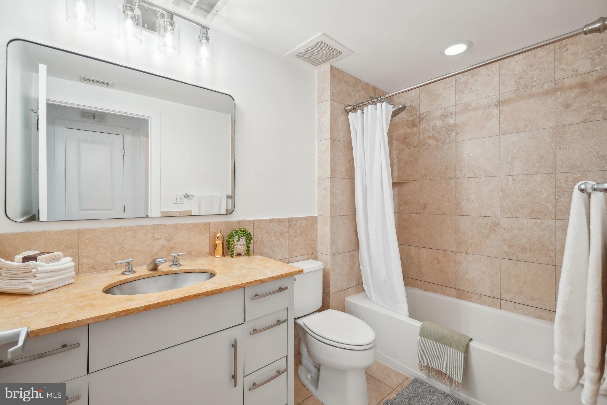 2301 Champlain Street Northwest, Unit 412 Washington, DC 20009 - Photo 9 of 20 a bathroom with a sink toilet a mirror and shower