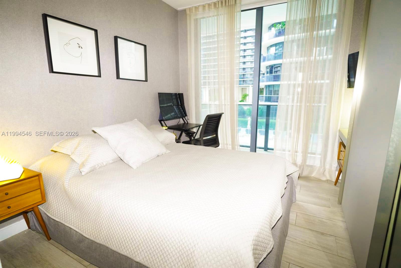 55 Southwest 9th Street, Unit 1001 Miami, FL 33130 - Photo 19 of 30 a white bed sitting in a bedroom next to a window