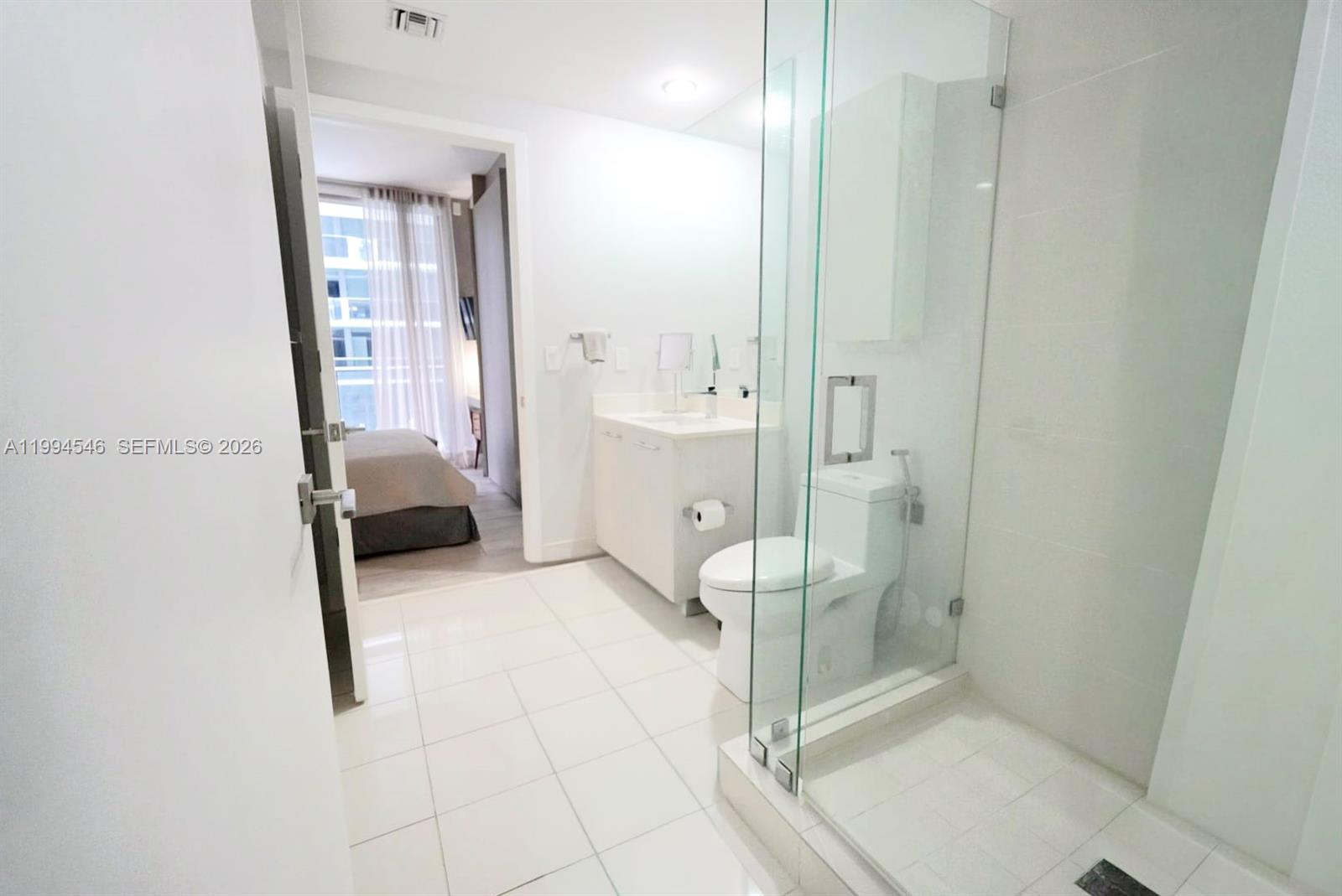 55 Southwest 9th Street, Unit 1001 Miami, FL 33130 - Photo 23 of 30 a bathroom with a tub and a glass door shower