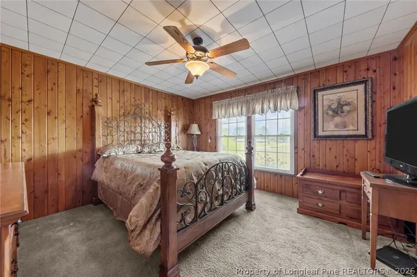 a spacious bedroom with a bed and a flat screen tv