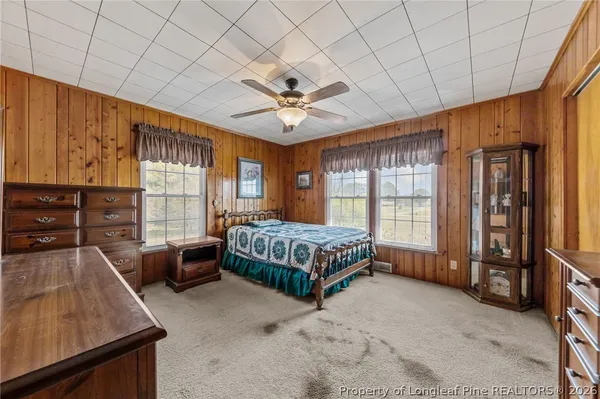 a bedroom with a bed and large window with balcony view