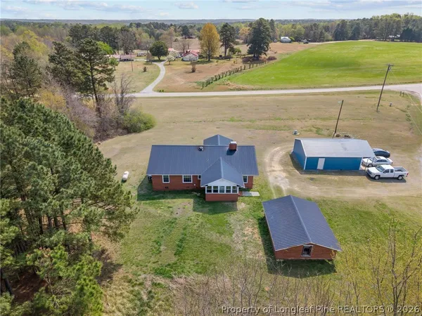 an aerial view of a house with a garden and lake view