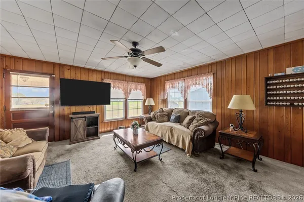 a living room with furniture a flat screen tv and a large window