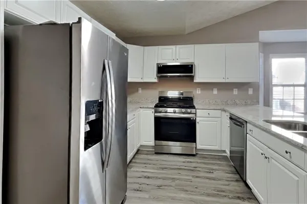 a kitchen with stainless steel appliances a refrigerator stove and sink