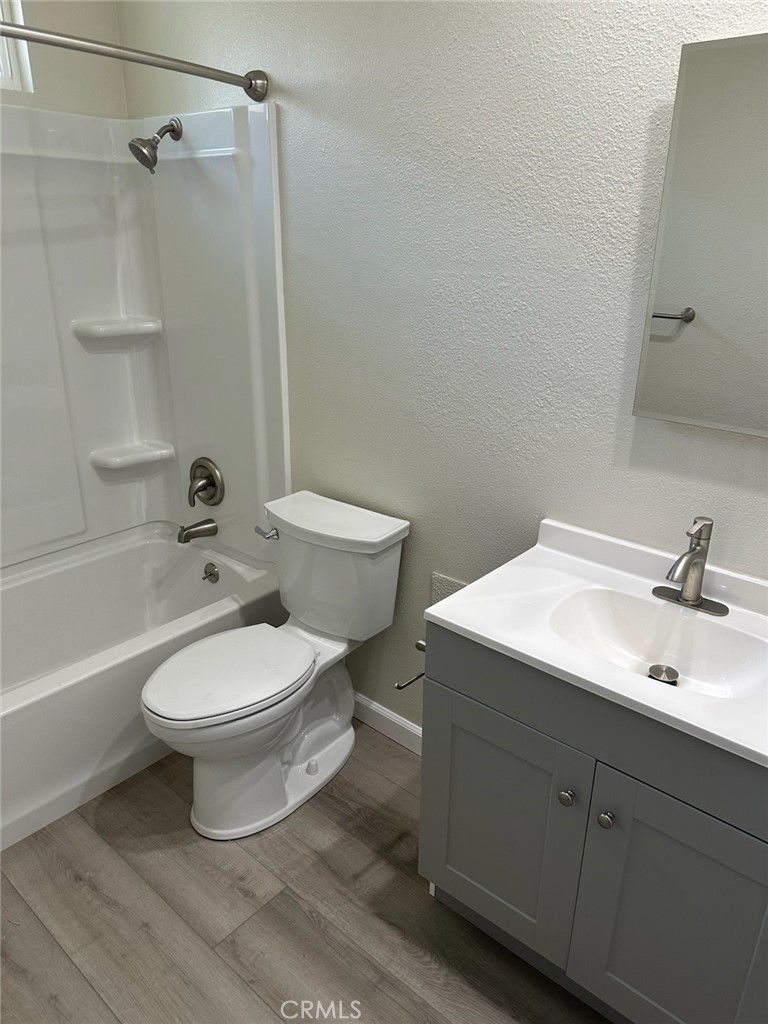 15702 Halldale Avenue Gardena, CA 90247 - Photo 19 of 25 a bathroom with a toilet a sink a mirror and vanity