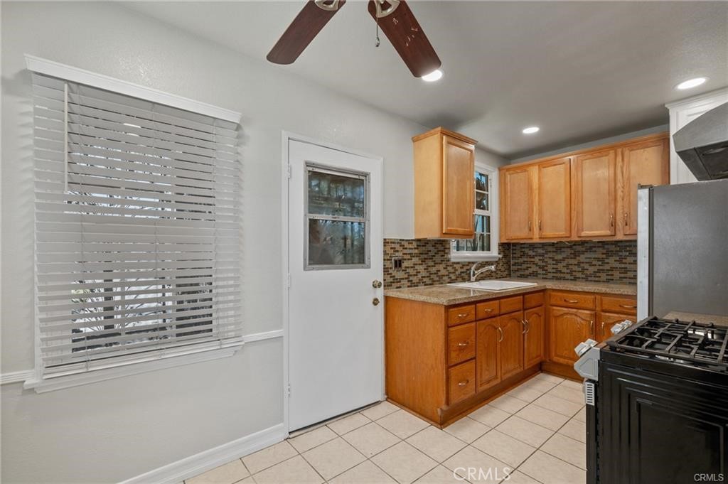 15702 Halldale Avenue Gardena, CA 90247 - Photo 10 of 25 a kitchen with stainless steel appliances granite countertop a stove a sink and a refrigerator
