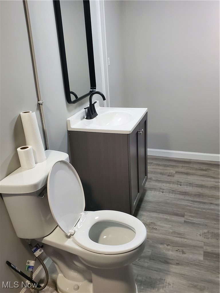 7007 Biddulph Road Brooklyn, OH 44144 - Photo 13 of 16 Half bath featuring vanity, toilet, wood finished floors, and baseboards