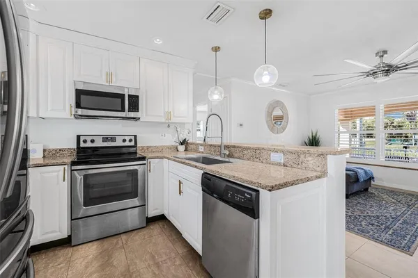a kitchen with granite countertop stainless steel appliances and a wooden floor