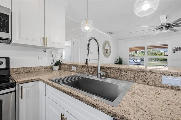a kitchen with stainless steel appliances granite countertop a sink a stove and a granite counter tops
