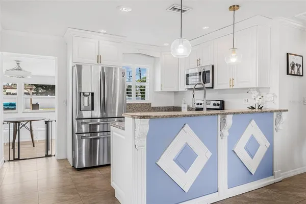 a kitchen with kitchen island white cabinets and stainless steel appliances