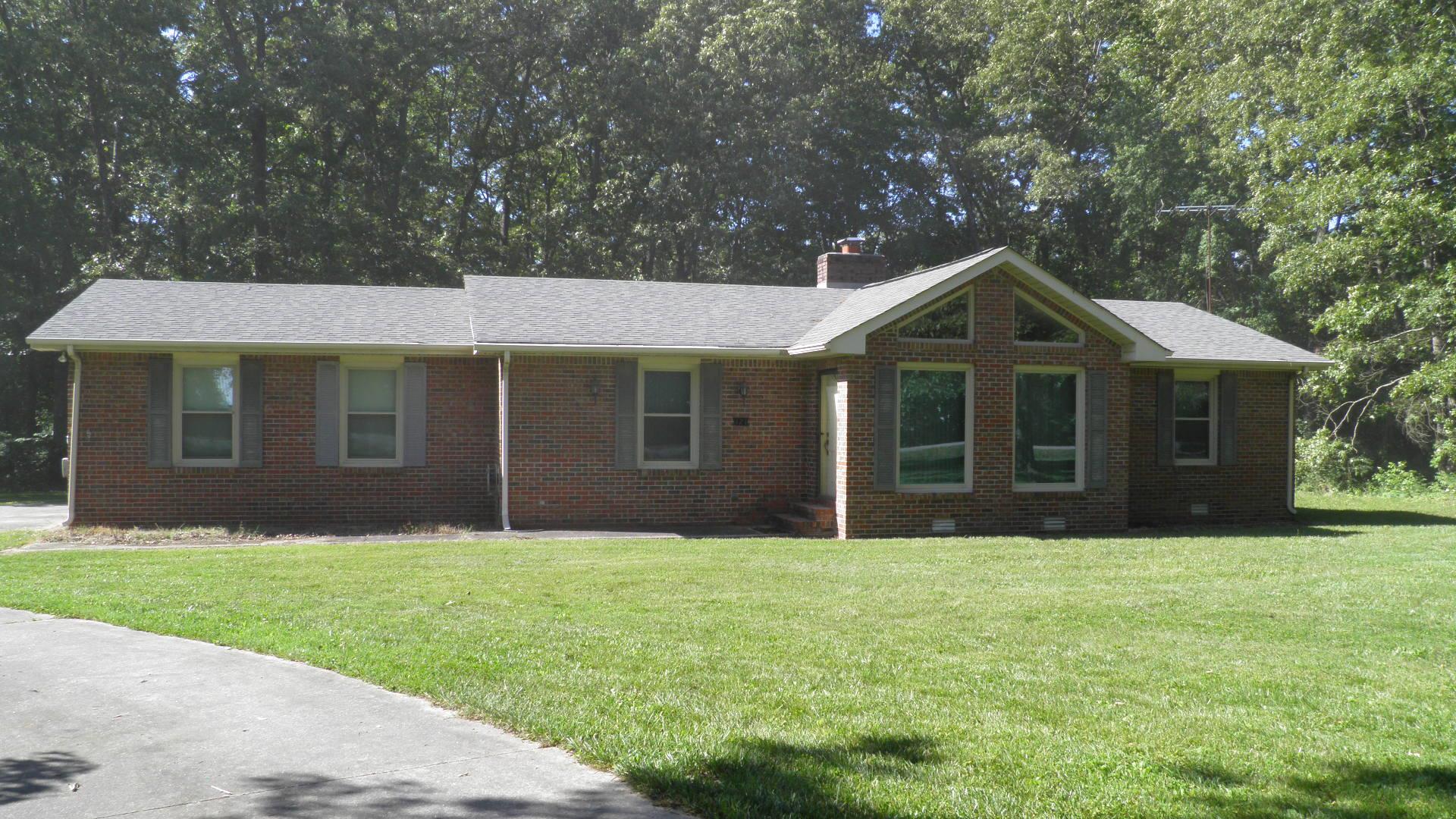 121 Asbury Road Manchester, TN 37355 - Photo 1 of 13 a front view of a house with a yard