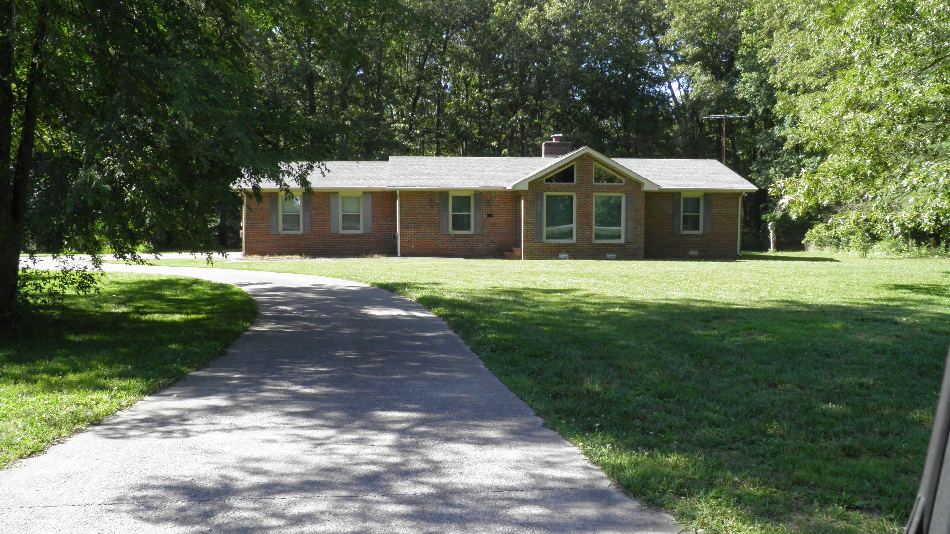 121 Asbury Road Manchester, TN 37355 - Photo 13 of 13 a front view of a house with a yard and garage