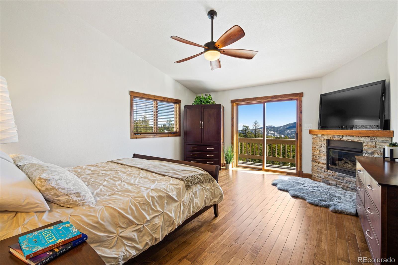8331 South Warhawk Road Conifer, CO 80433 - Photo 15 of 40 a bedroom with a bed and a flat screen tv with wooden floor