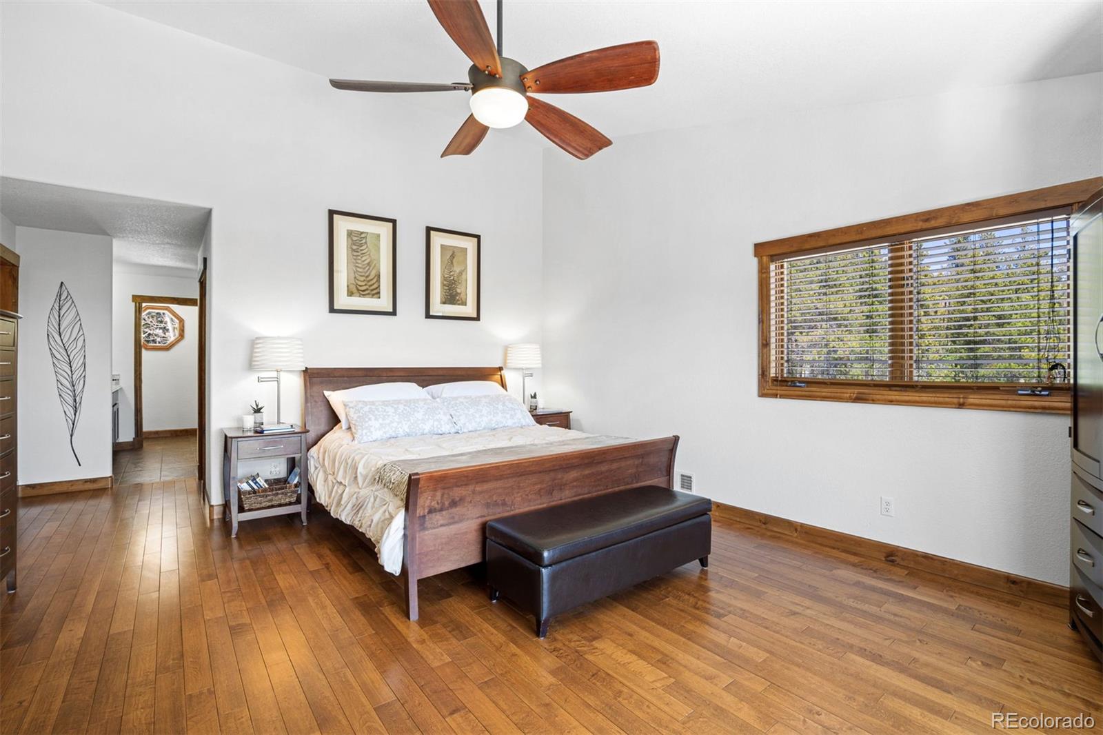 8331 South Warhawk Road Conifer, CO 80433 - Photo 18 of 40 a spacious bedroom with a bed and a large window