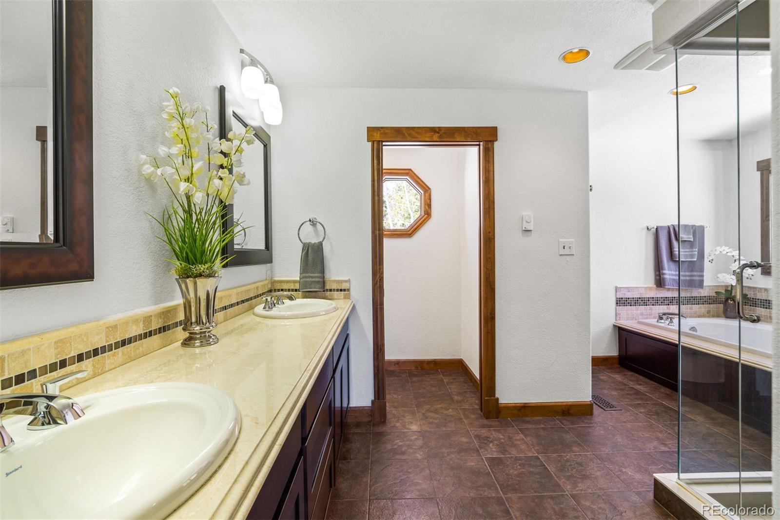 8331 South Warhawk Road Conifer, CO 80433 - Photo 19 of 40 a en suite bathroom with a sink and a mirror