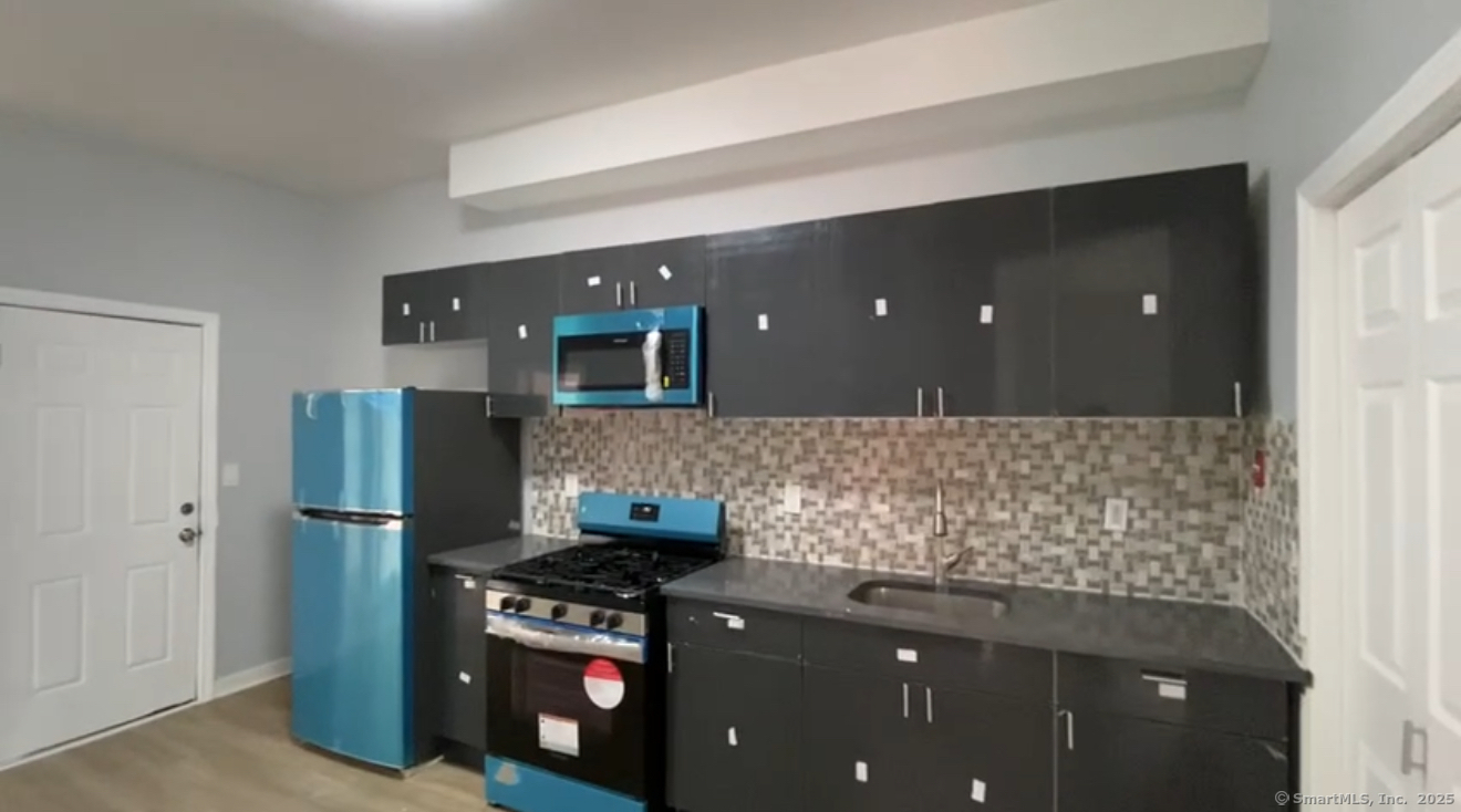 a kitchen with stainless steel appliances granite countertop a refrigerator and a stove