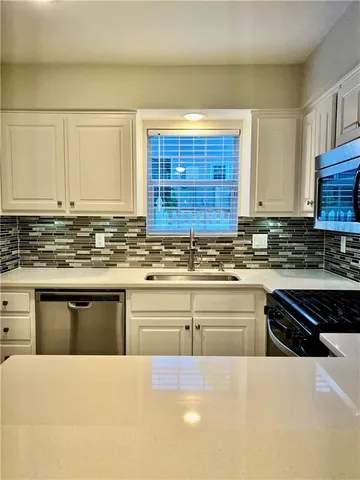 a kitchen with stainless steel appliances granite countertop a stove a sink and a granite counter tops