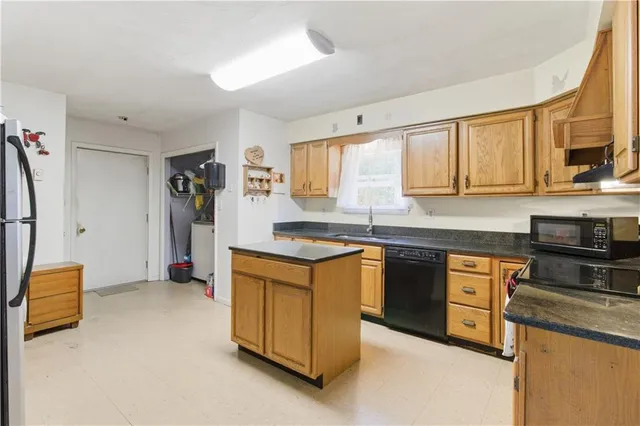 a kitchen with stainless steel appliances granite countertop a stove a sink and a refrigerator