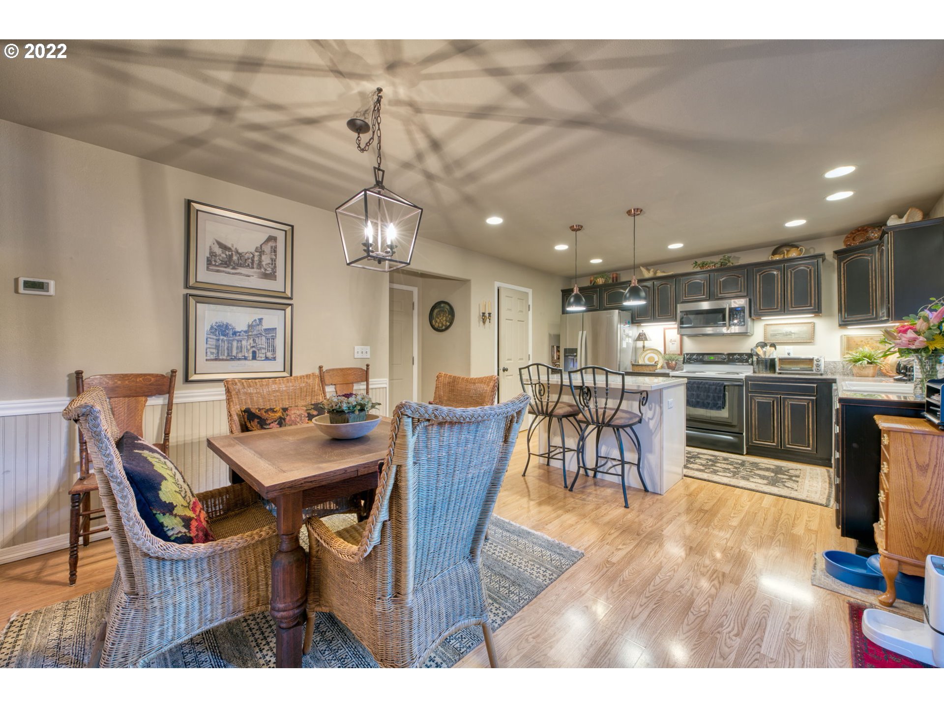 581 South 72nd Street Springfield, OR 97478 - Photo 9 of 25 a dining room with wooden floor a chandelier a wooden table and chairs