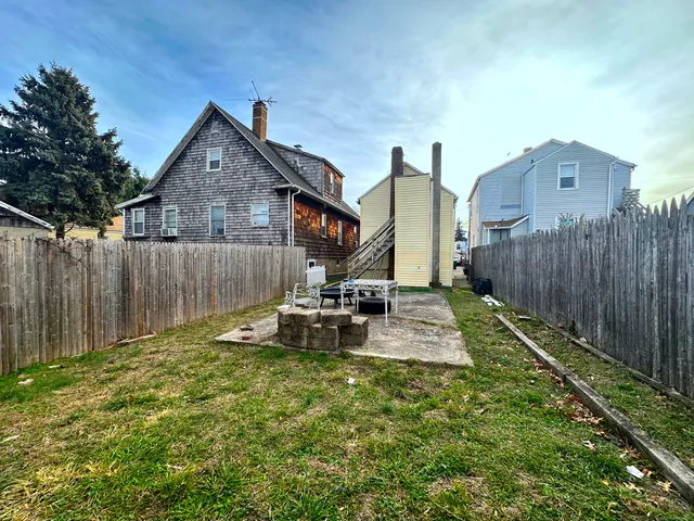 a view of a house with backyard and sitting area