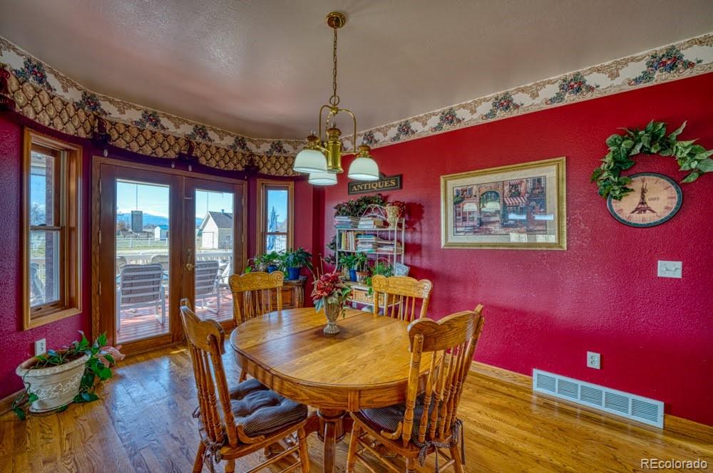 8283 Hygiene Road Longmont, CO 80503 - Photo 12 of 27 a view of a dining room with furniture a chandelier and wooden floor