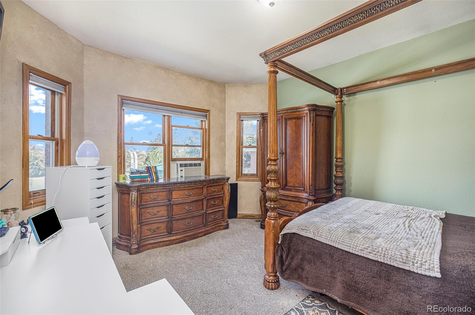 8283 Hygiene Road Longmont, CO 80503 - Photo 15 of 27 a bedroom with a bed and dresser with mirror