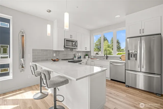 a kitchen with kitchen island a stove a sink and a refrigerator
