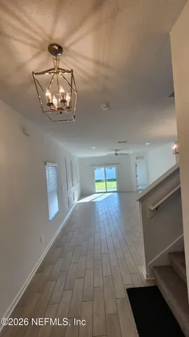 a view of a room with wooden floor and chandelier