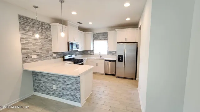 a kitchen with stainless steel appliances granite countertop a refrigerator a stove a sink dishwasher and a refrigerator