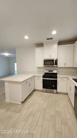 a kitchen with granite countertop a stove and cabinets