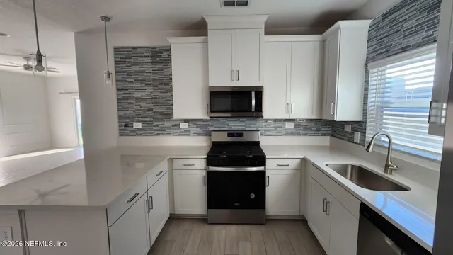 a kitchen with a sink stove and microwave