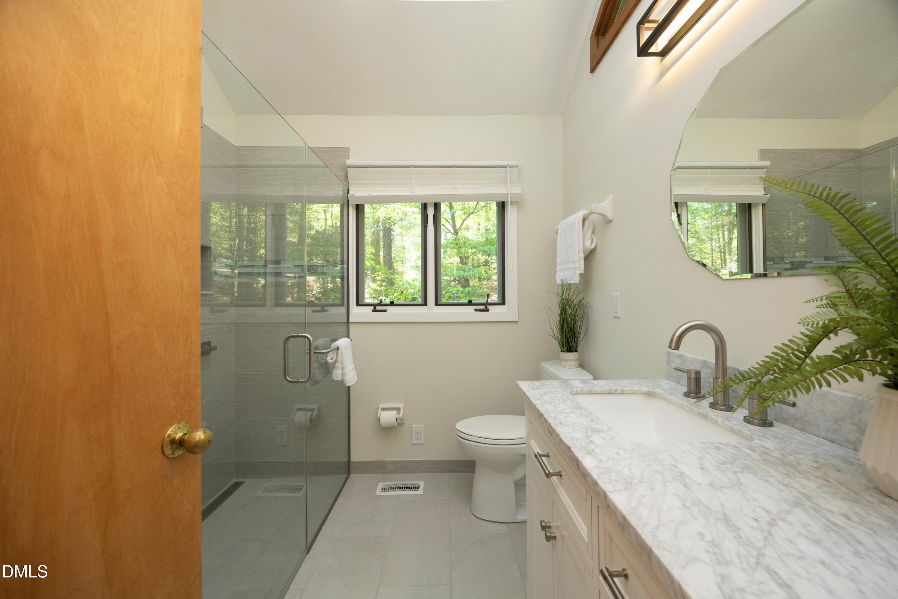 5321 Taproot Lane Durham, NC 27705 - Photo 13 of 27 a bathroom with a granite countertop sink toilet and shower