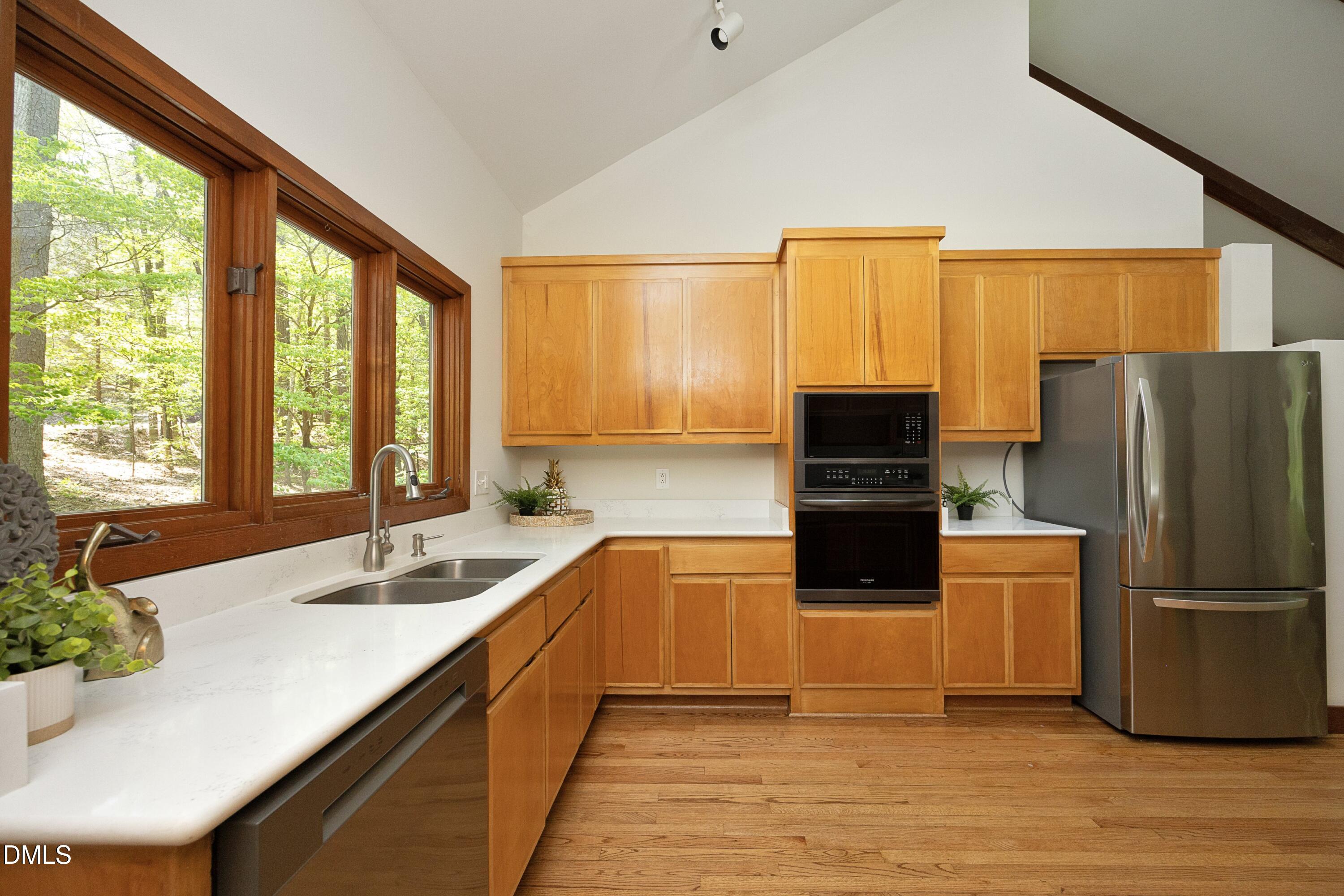 5321 Taproot Lane Durham, NC 27705 - Photo 8 of 27 a kitchen with a refrigerator a sink and dishwasher with wooden floor