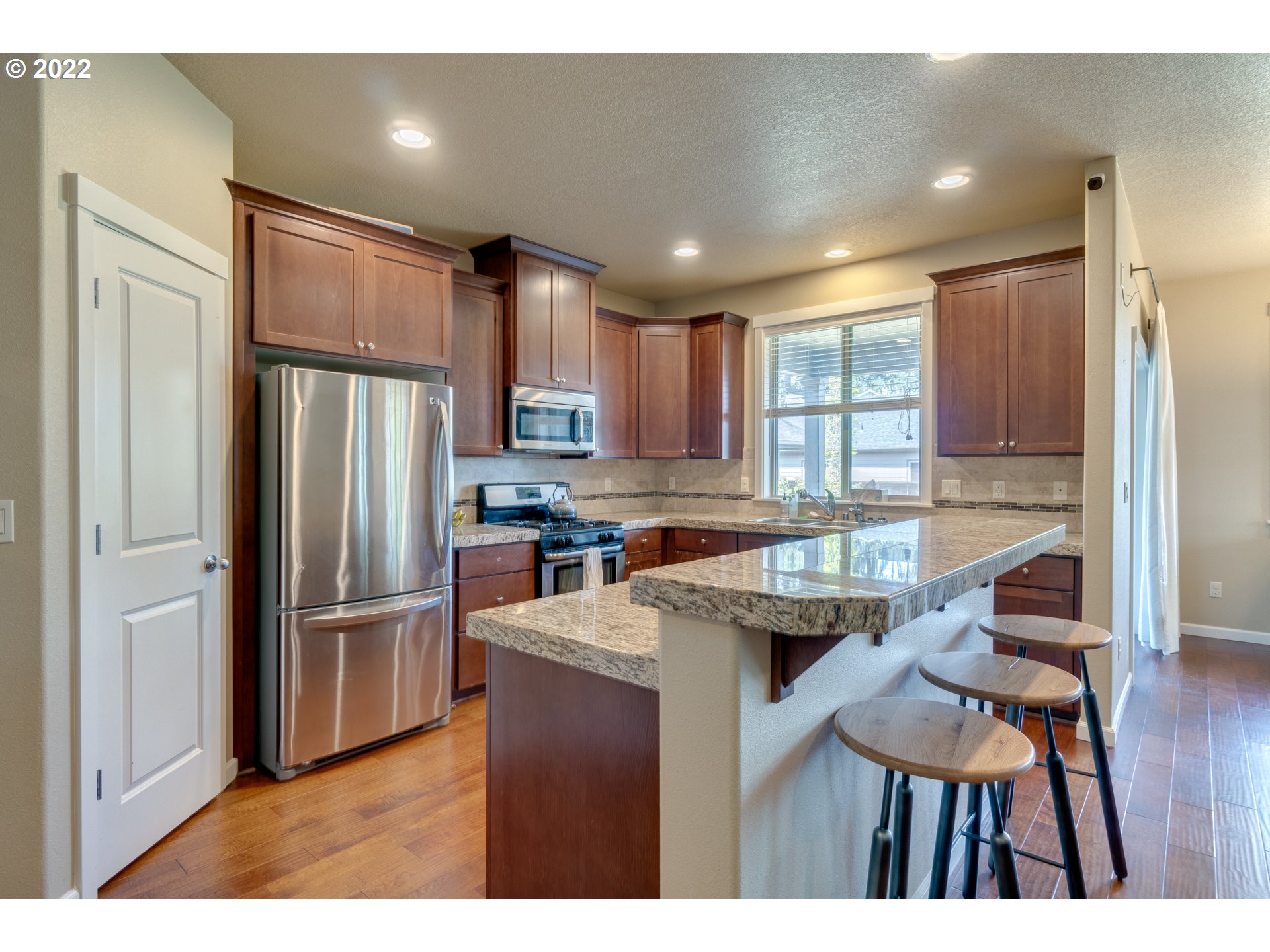 4310 North 4th Circle Ridgefield, WA 98642 - Photo 6 of 27 a kitchen with refrigerator cabinets dining table and chairs