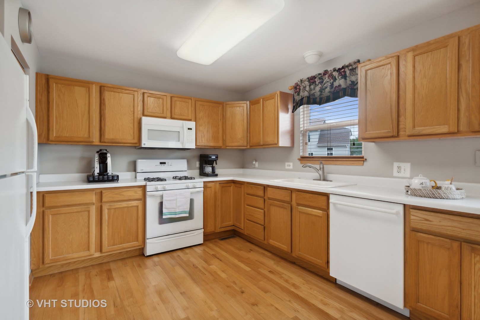 946 Premrose Court Romeoville, IL 60446 - Photo 6 of 25 a kitchen with stainless steel appliances granite countertop a stove a sink dishwasher and a microwave oven with cabinets