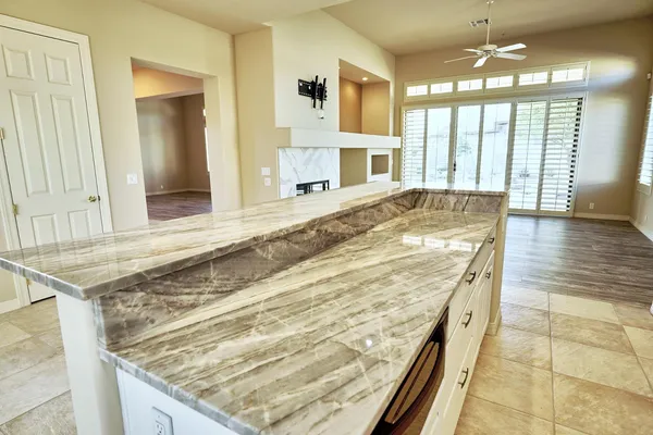 a large kitchen with granite countertop a large counter top stainless steel appliances and cabinets