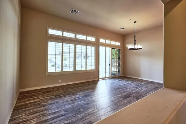 an empty room with a window and a ceiling fan