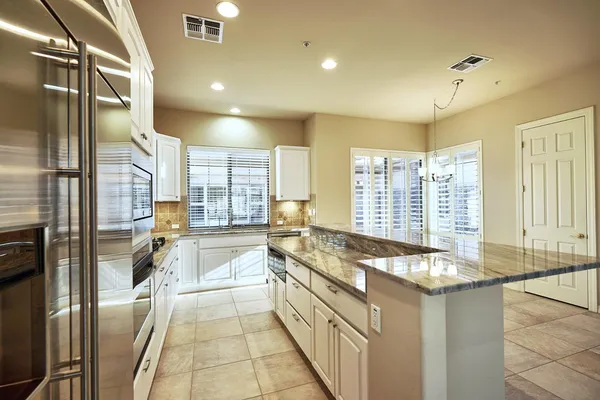 a kitchen with stainless steel appliances granite countertop a sink stove and refrigerator