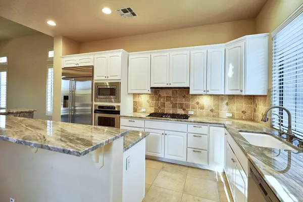 a kitchen with stainless steel appliances granite countertop a refrigerator and a sink