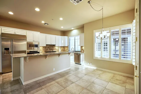 a spacious bathroom with a granite countertop sink and a mirror