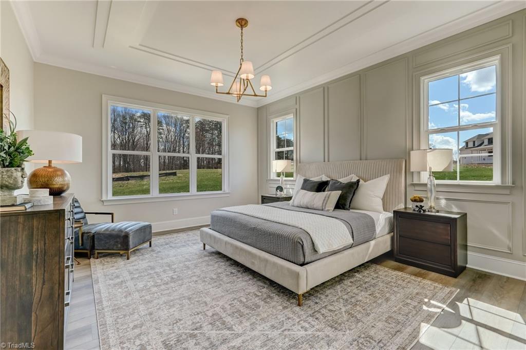 6806 Brennan Way Oak Ridge, NC 27310 - Photo 4 of 50 primary bedroom with architecturally detailed ceiling and walls, ample natural light
