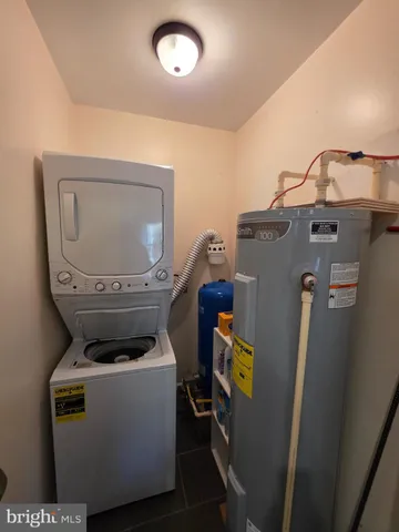 a view of a backyard with table and chairs potted plants and a large tree