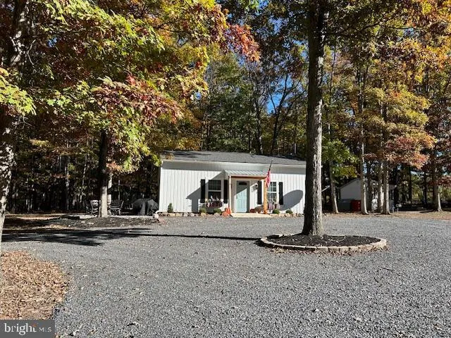 a view of house with backyard and outdoor seating