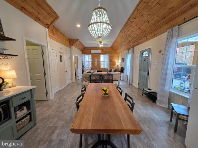 a kitchen with a refrigerator a stove a sink and a dining table with wooden floor